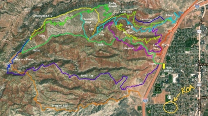 Satellite map showing various ATV trail routes marked in different colors near a residential area; "KOA" is circled in yellow on the right side of the image.