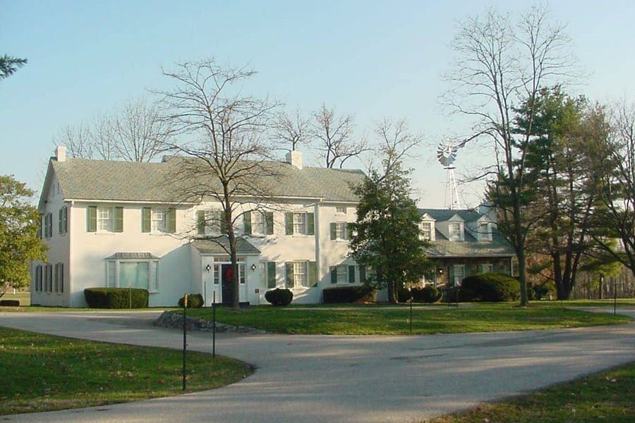 Eisenhower National Historic Site surrounded by trees and a circular driveway, under a clear sky.